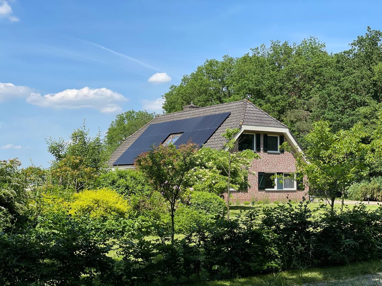 Woning met zonnepanelen in groene omgeving